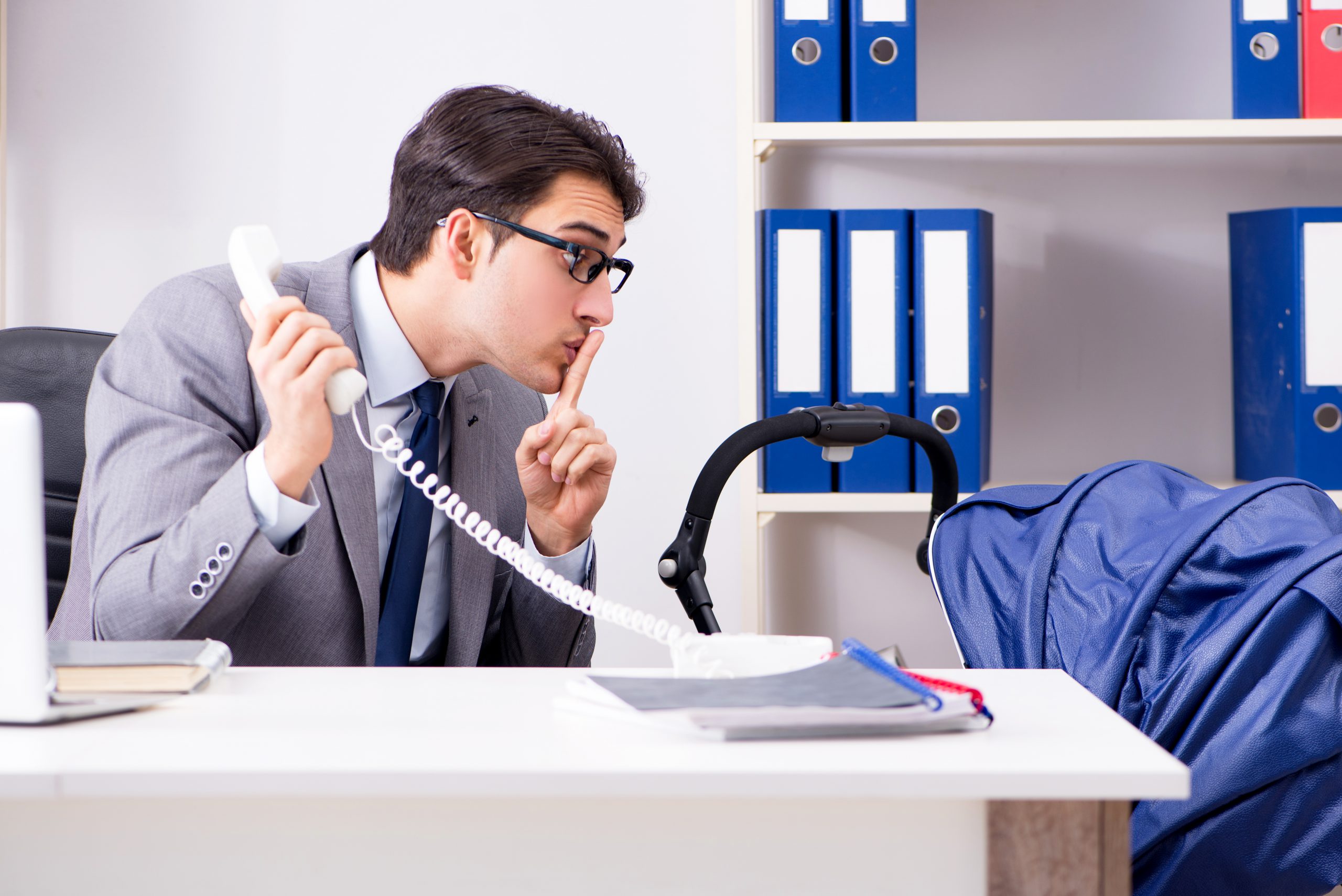 Businessman looking after newborn baby in office